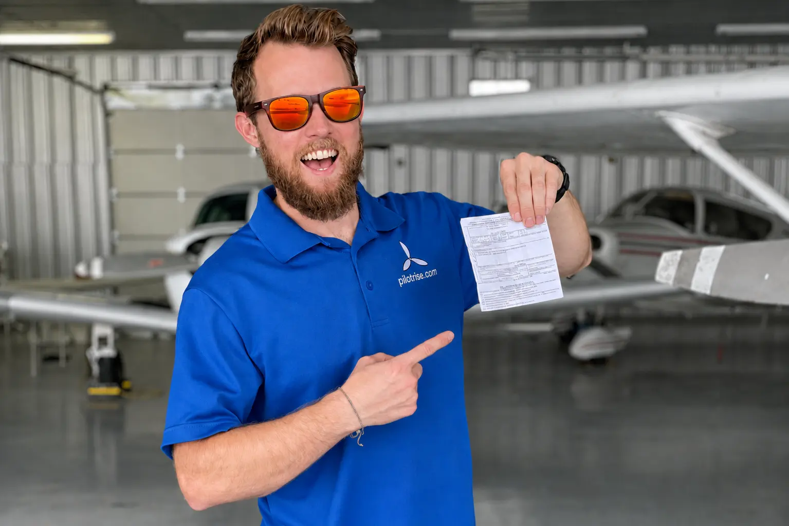 Karl holding his new Commercial Pilot Certificate - Student Success