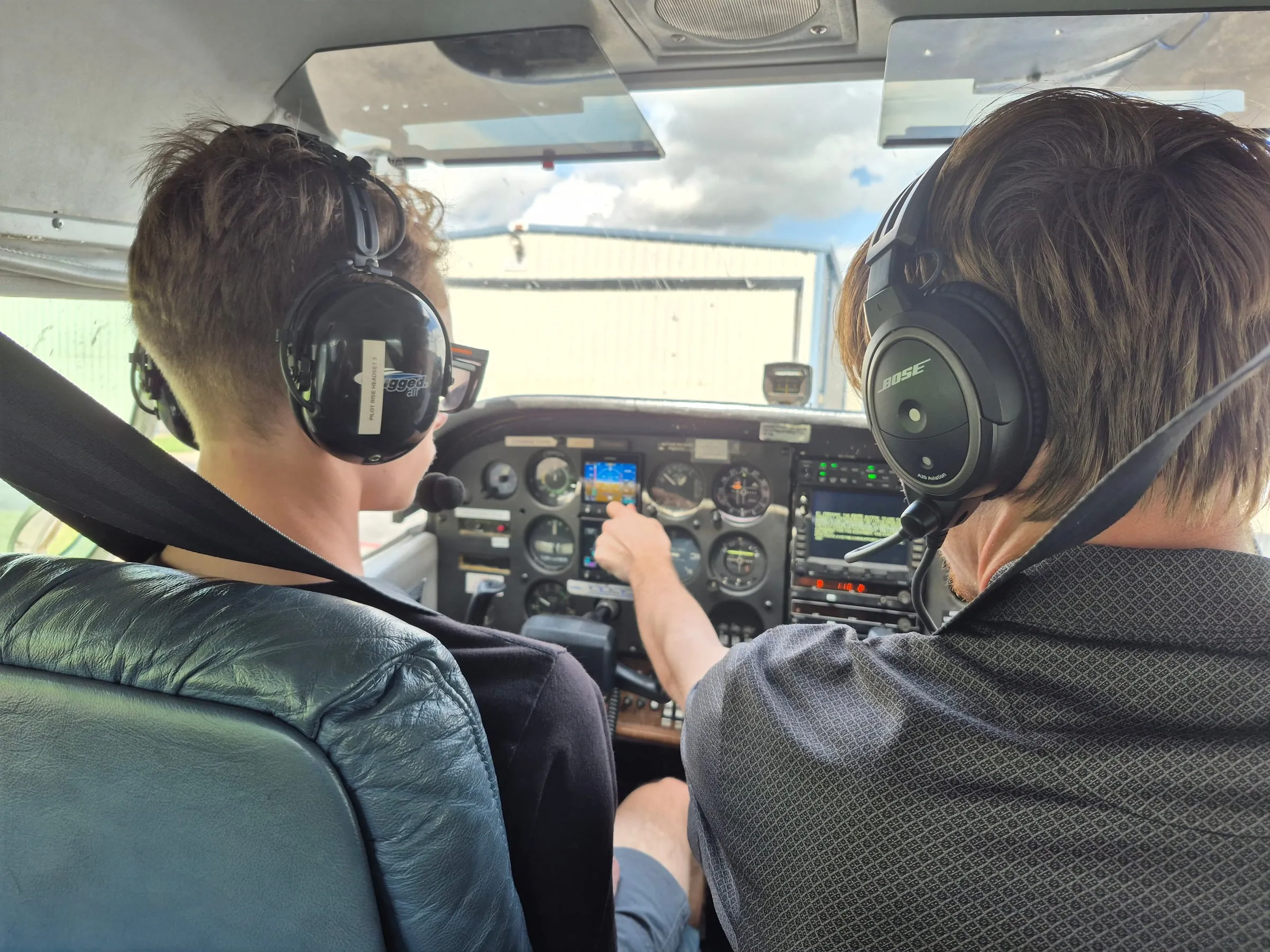 Flight instructor teaching a student pilot in an airplane cockpit