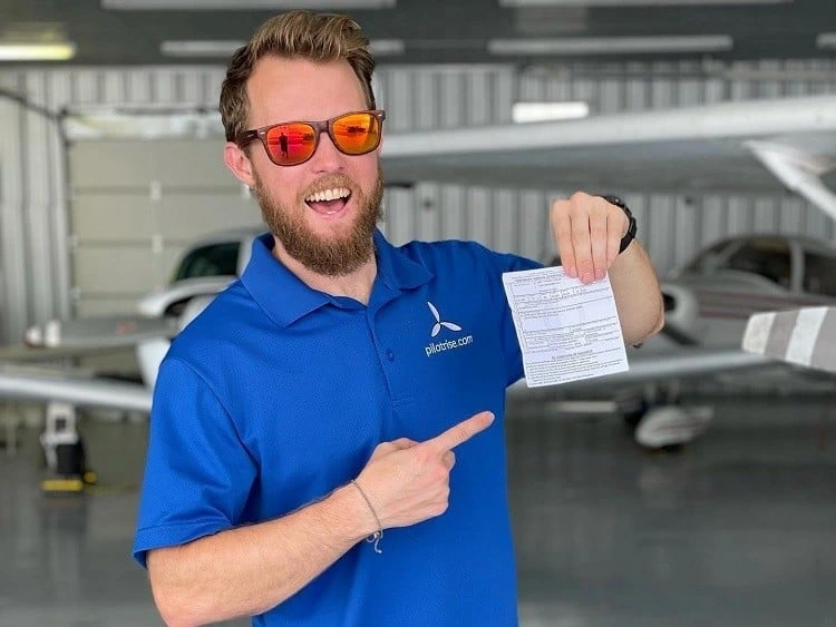 Pilot Rise student holding a Commercial Pilot certificate after a checkride