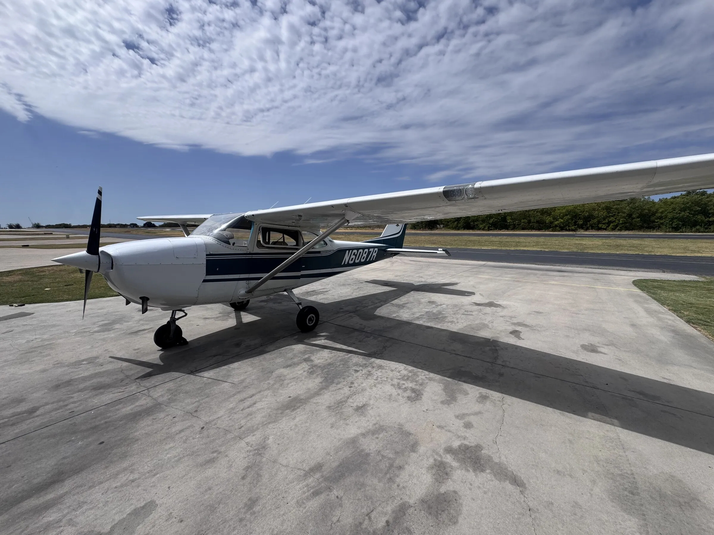 Wide left-side exterior view of Cessna 172G N6087R