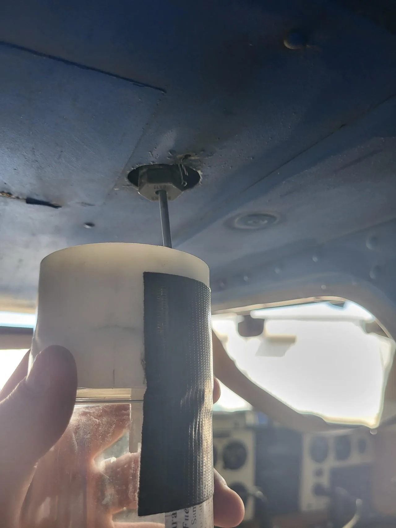Pilot draining an aircraft fuel sump